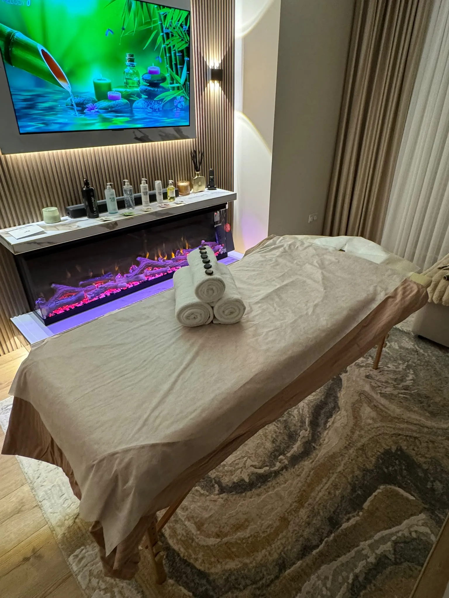 A folding massage table made up with a sheet and rolled towels, ready for a treatment